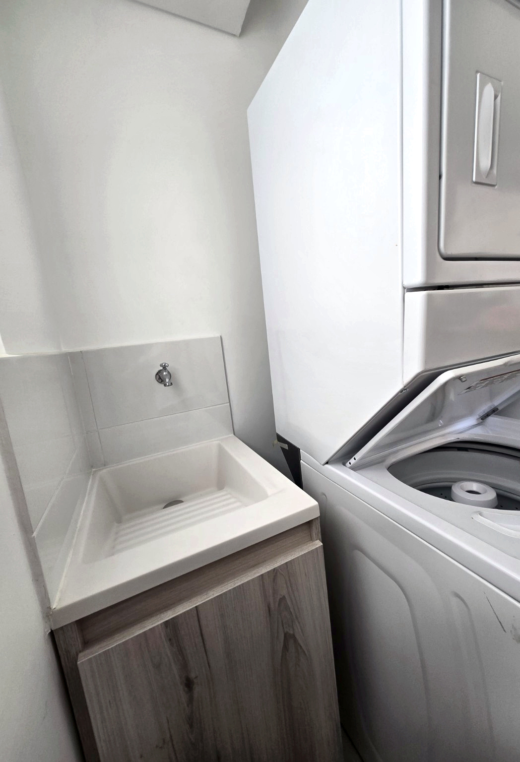 Capriella laundry sink beside the stacked washer and dryer