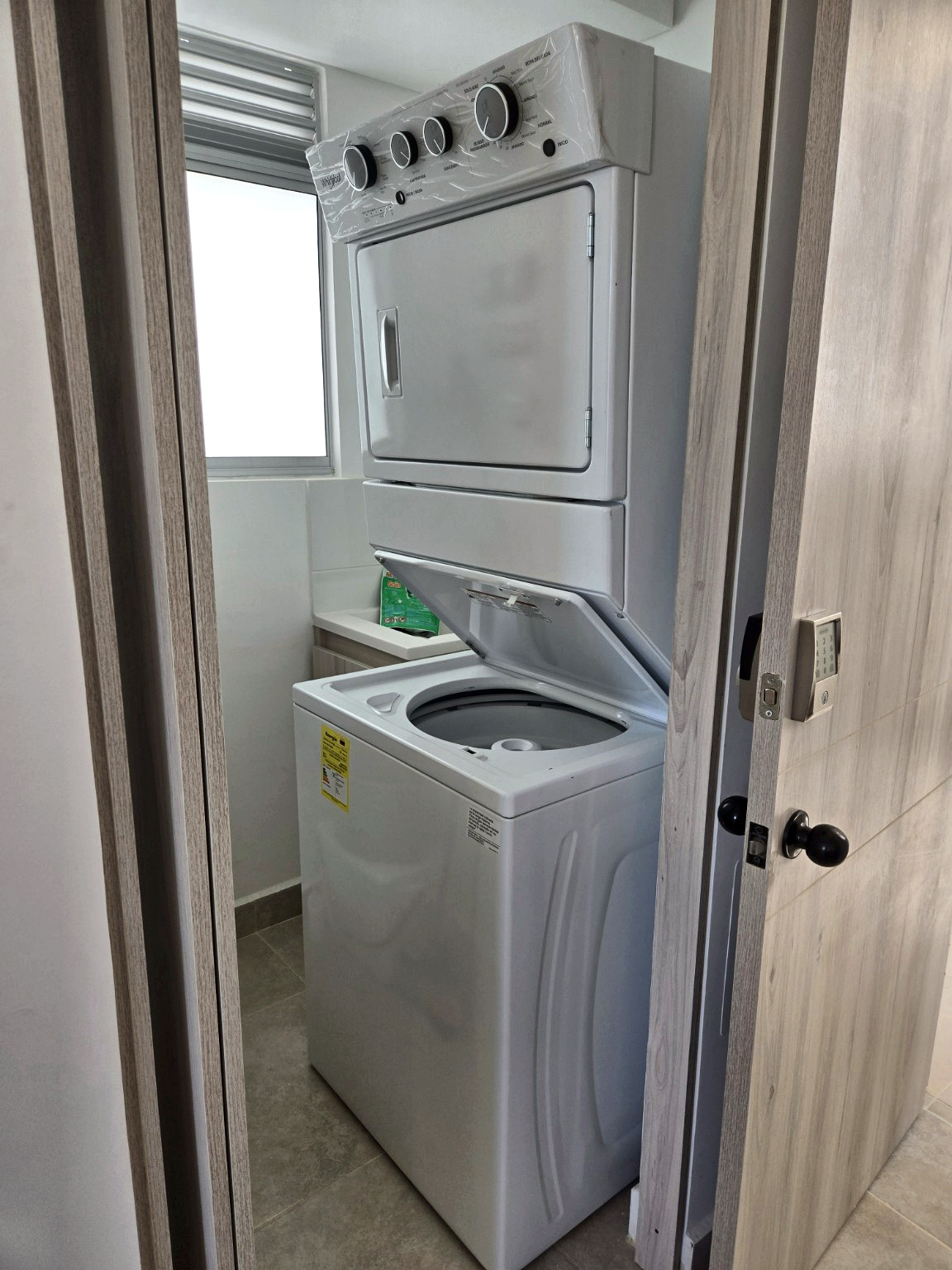 Capriella stacked washer and dryer viewed through the laundry doorway