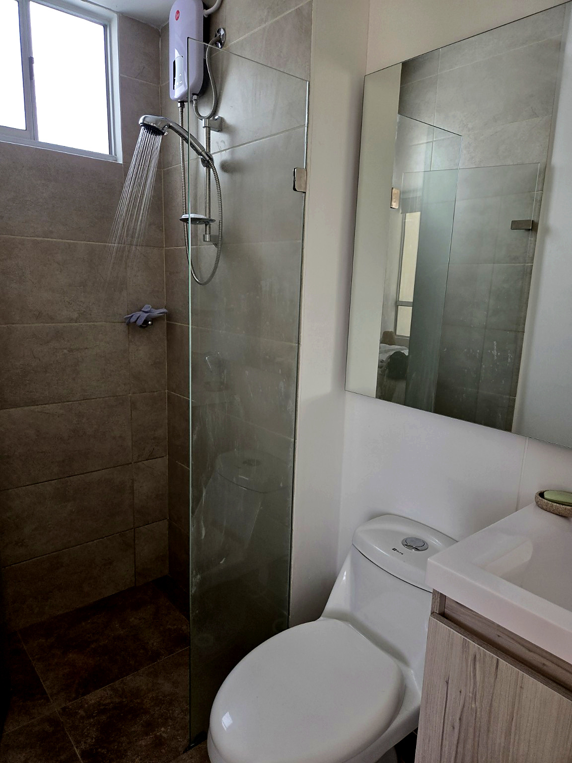 Capriella bathroom shower with glass partition and dual-flush toilet