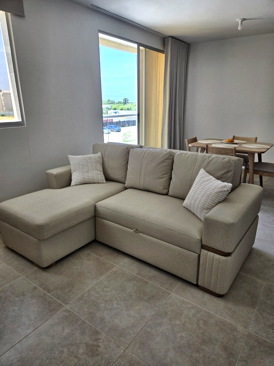 Capriella living room with corner sofa beside the balcony doors