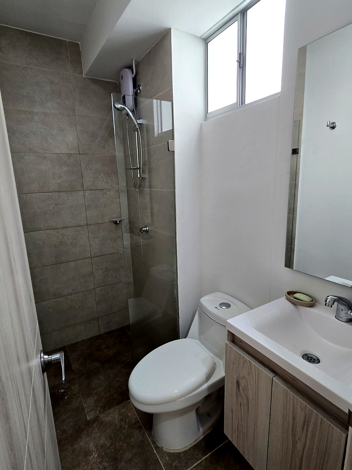 Capriella bathroom with glass shower screen, toilet and wall-mounted sink