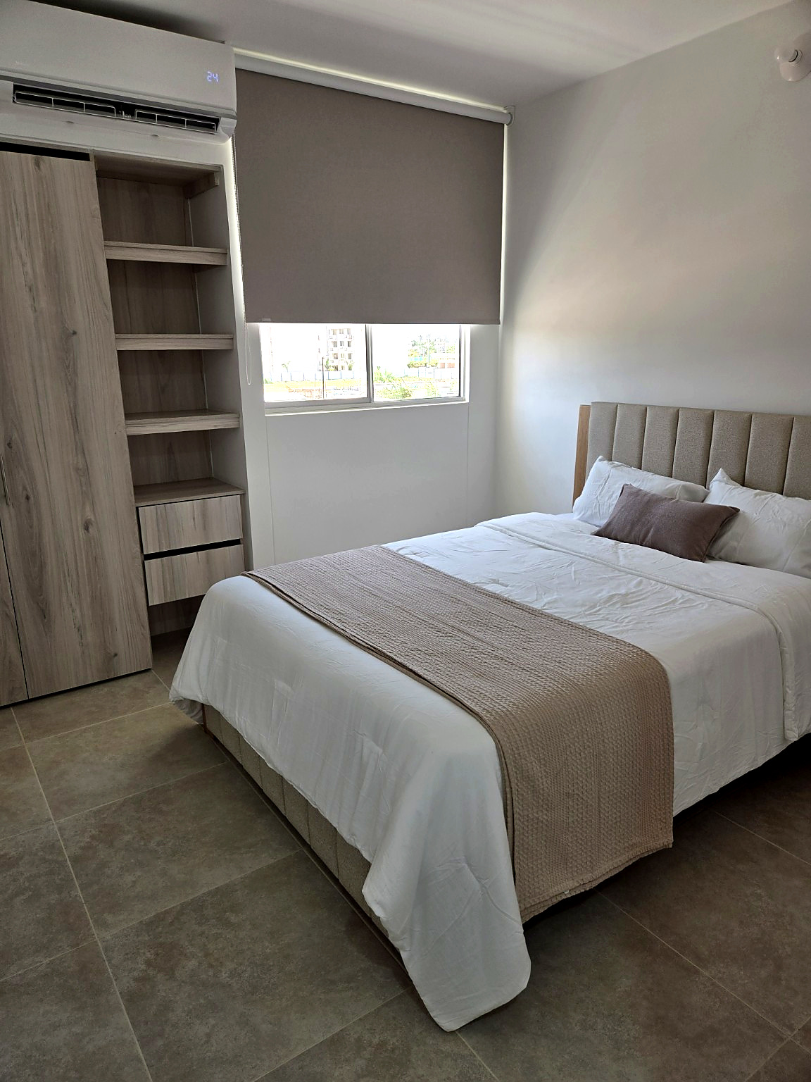 Capriella bedroom with built-in wardrobe shelving and a window view